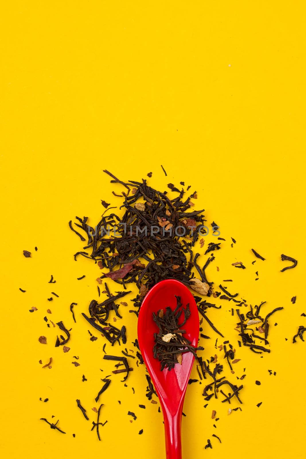 Tea composition with spoon on yellow background