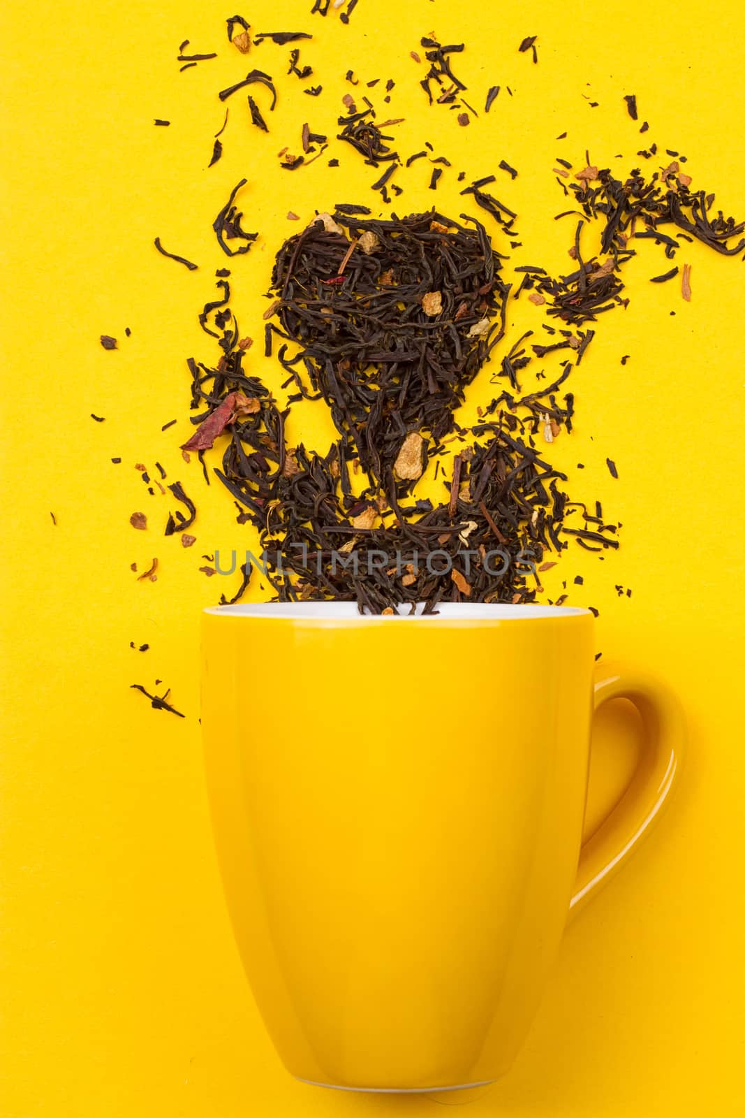 Falling driedn teain cup on yellow background white background
