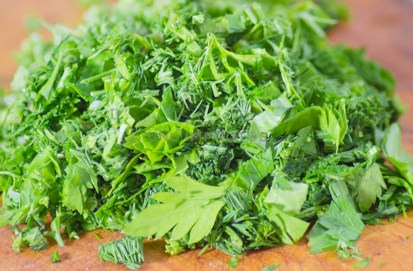 Chopped parsley and dill on cutting board closeup by anmbph