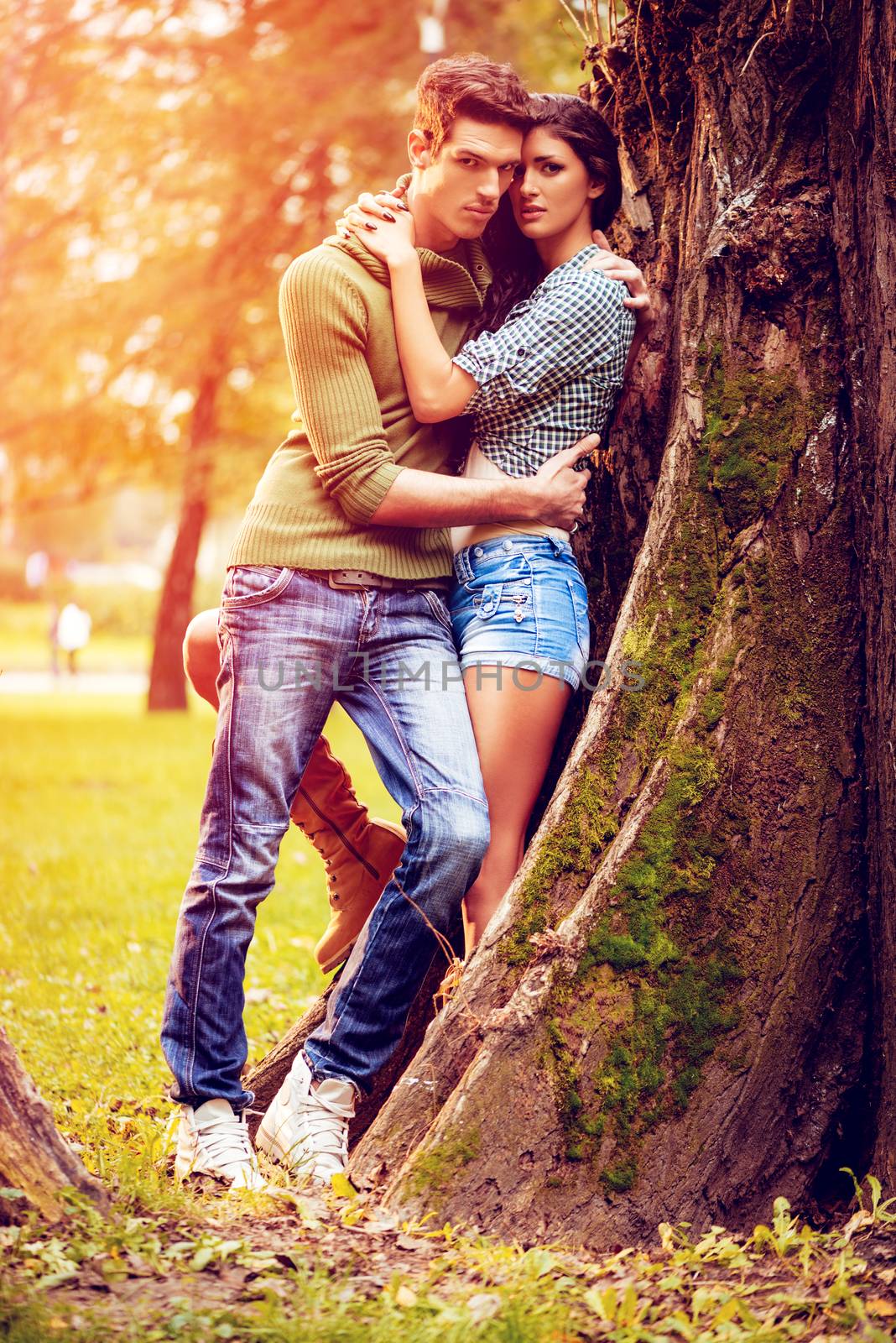 Beautiful lovely couple enjoying in sunny park in autumn colors.