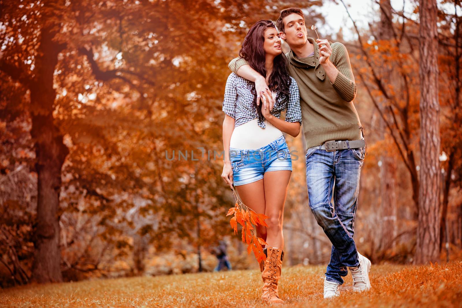 Beautiful lovely couple walking and enjoying in the park in autumn colors.