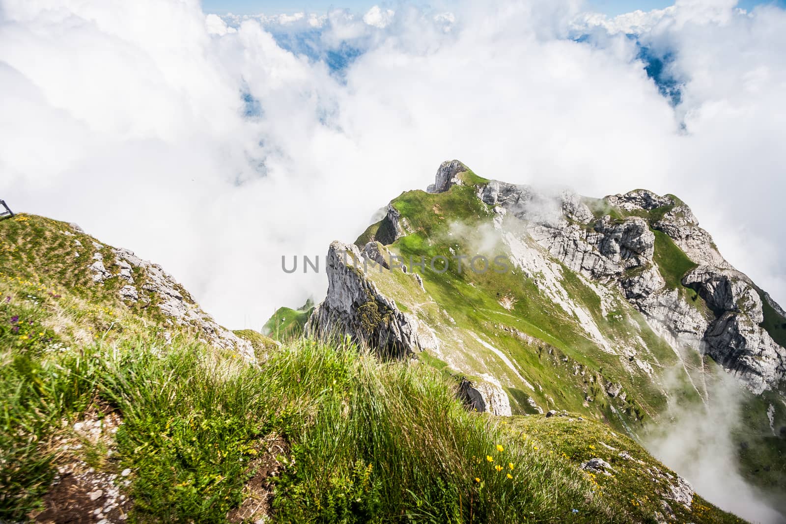 Great Majestic Dreamy Landscape View of Natural Swiss Alps from Mount Pilatus Peak. Breathtaking view of Steep Cliff surrounded with creeping fog and cloud.