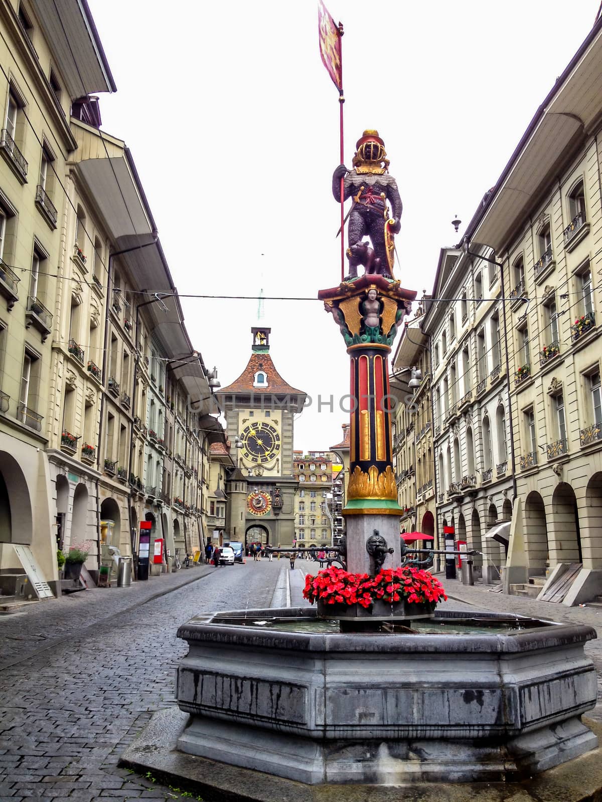 Beautiful City Street View of the colorful medieval Zahringen statue on top of elaborate fountain in Bern, Switzerland. The fountain is attributed to Hans Gieng in 16th century.