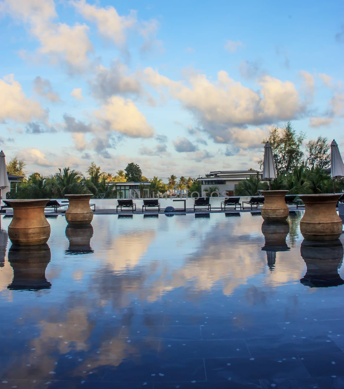 morning blue sky reflection in swimming pool on tropical beach by victorflowerfly