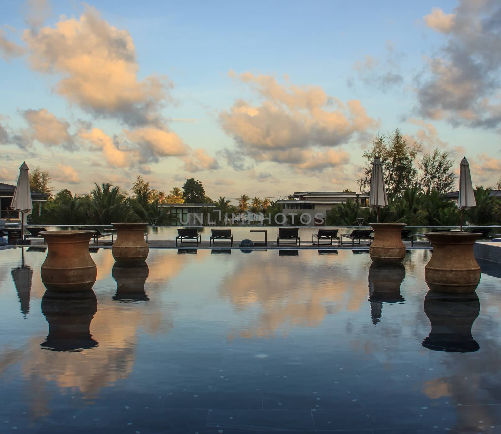 morning blue sky reflection in swimming pool on tropical beach