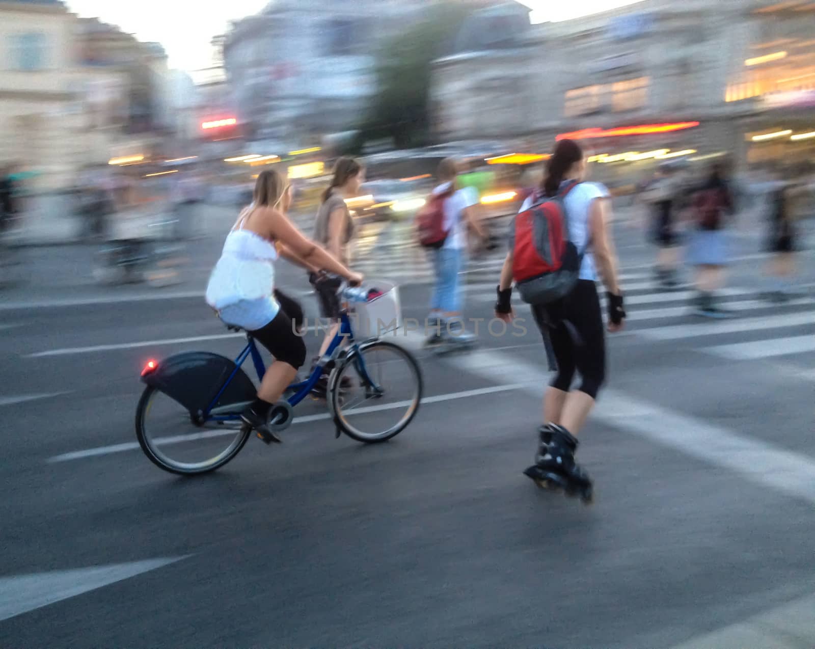 women on the move with bicycle and rollerskates, background blurred motion