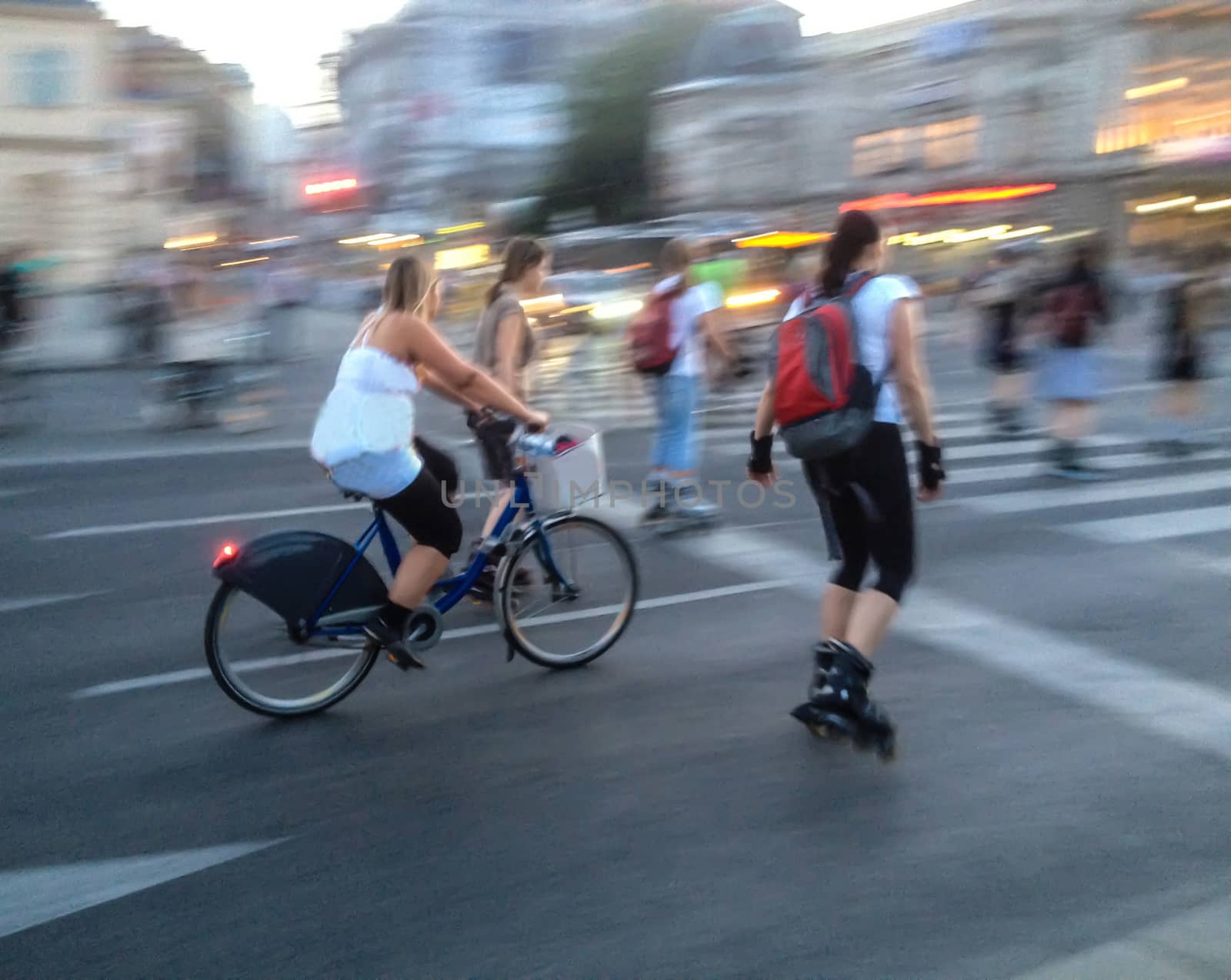 women on the move with bicycle and rollerskates, background blurred motion by victorflowerfly