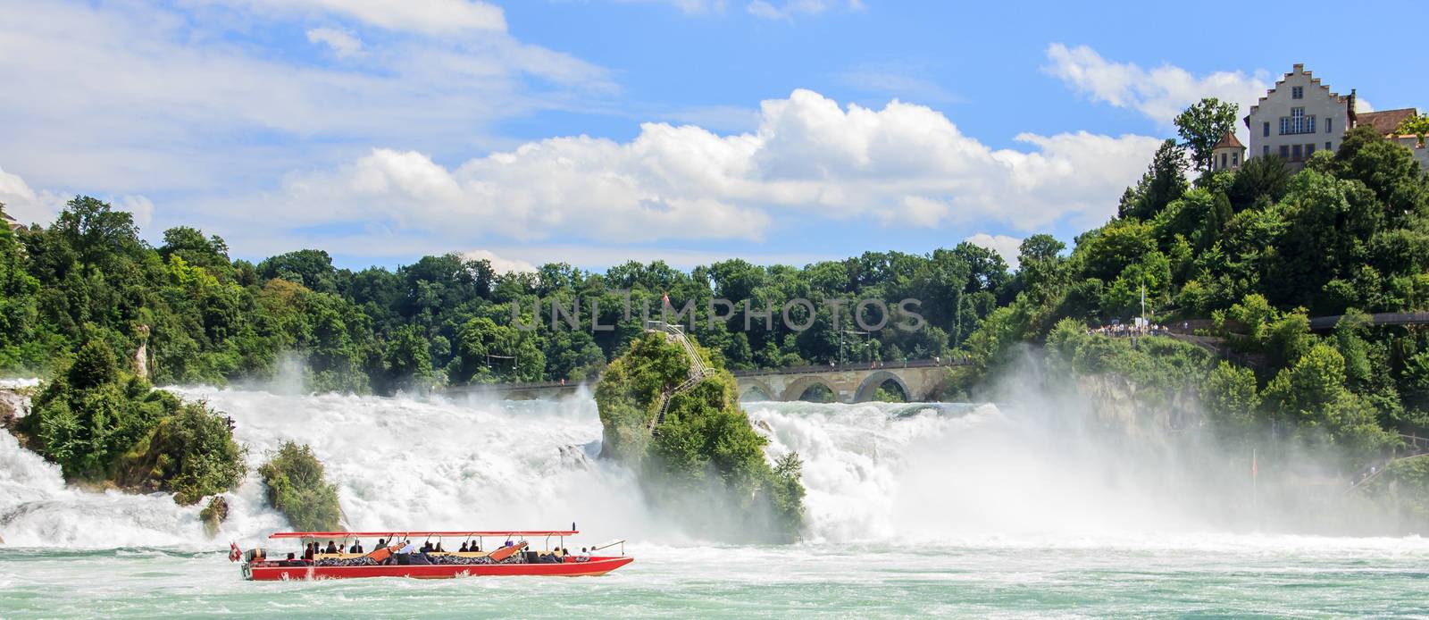 Boat with tourists at Rhine falls, the biggest waterfalls of Europe, in Schaffhausen, Switzerland. by victorflowerfly