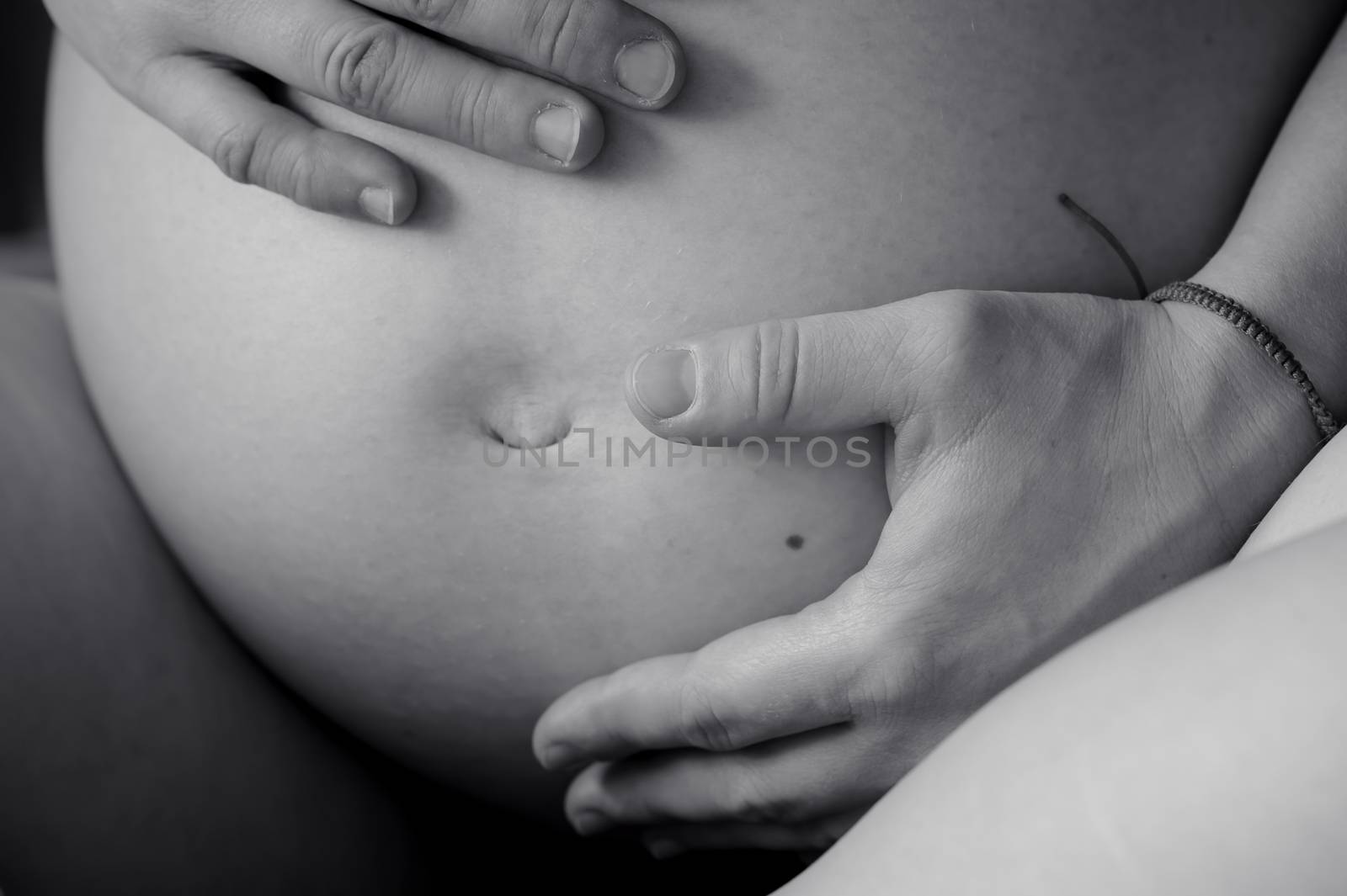 Black and white belly of pregnant woman closeup, nine month
