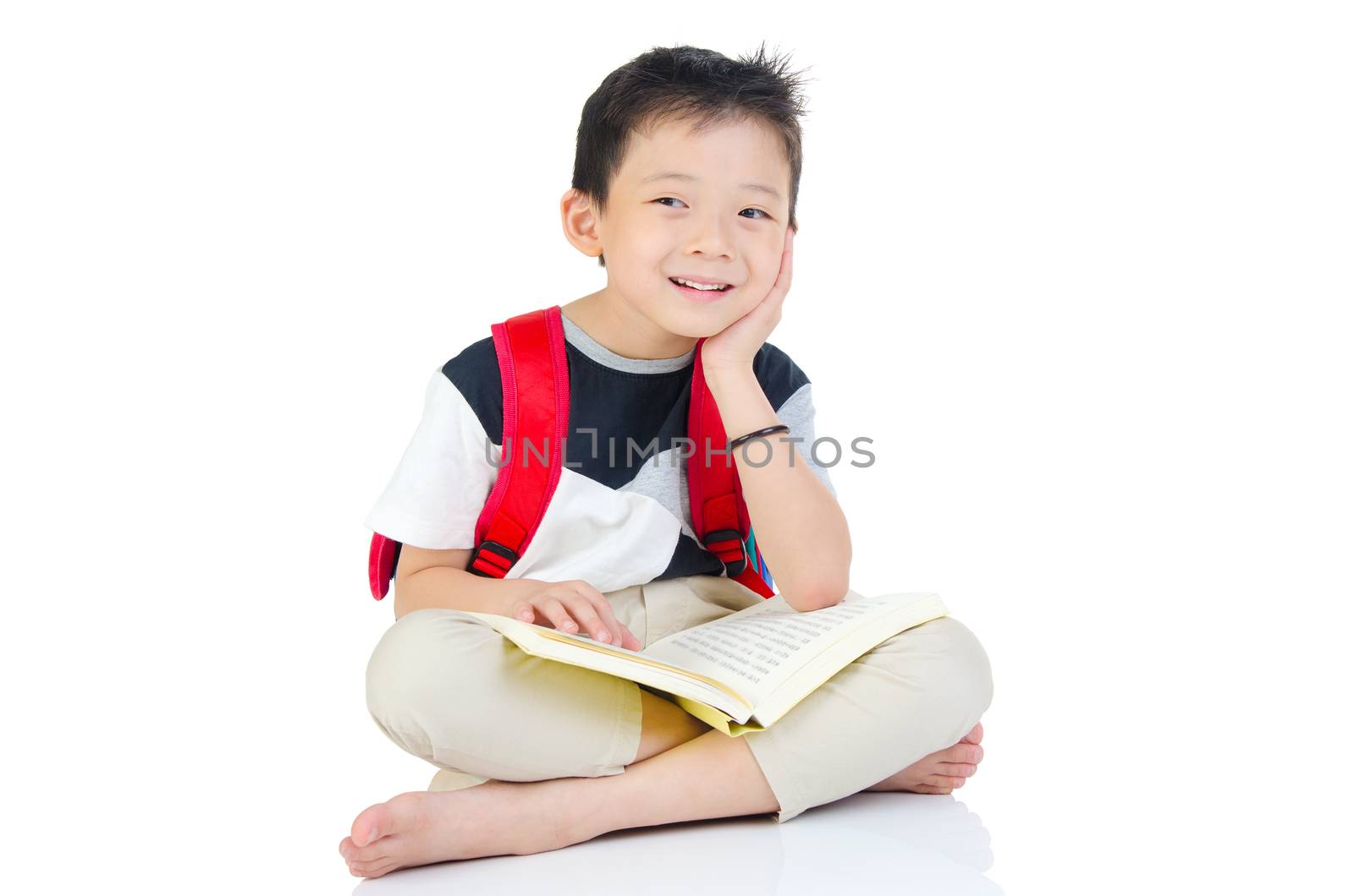 Asian preschool boy with schoolbag and books sitting on the floor