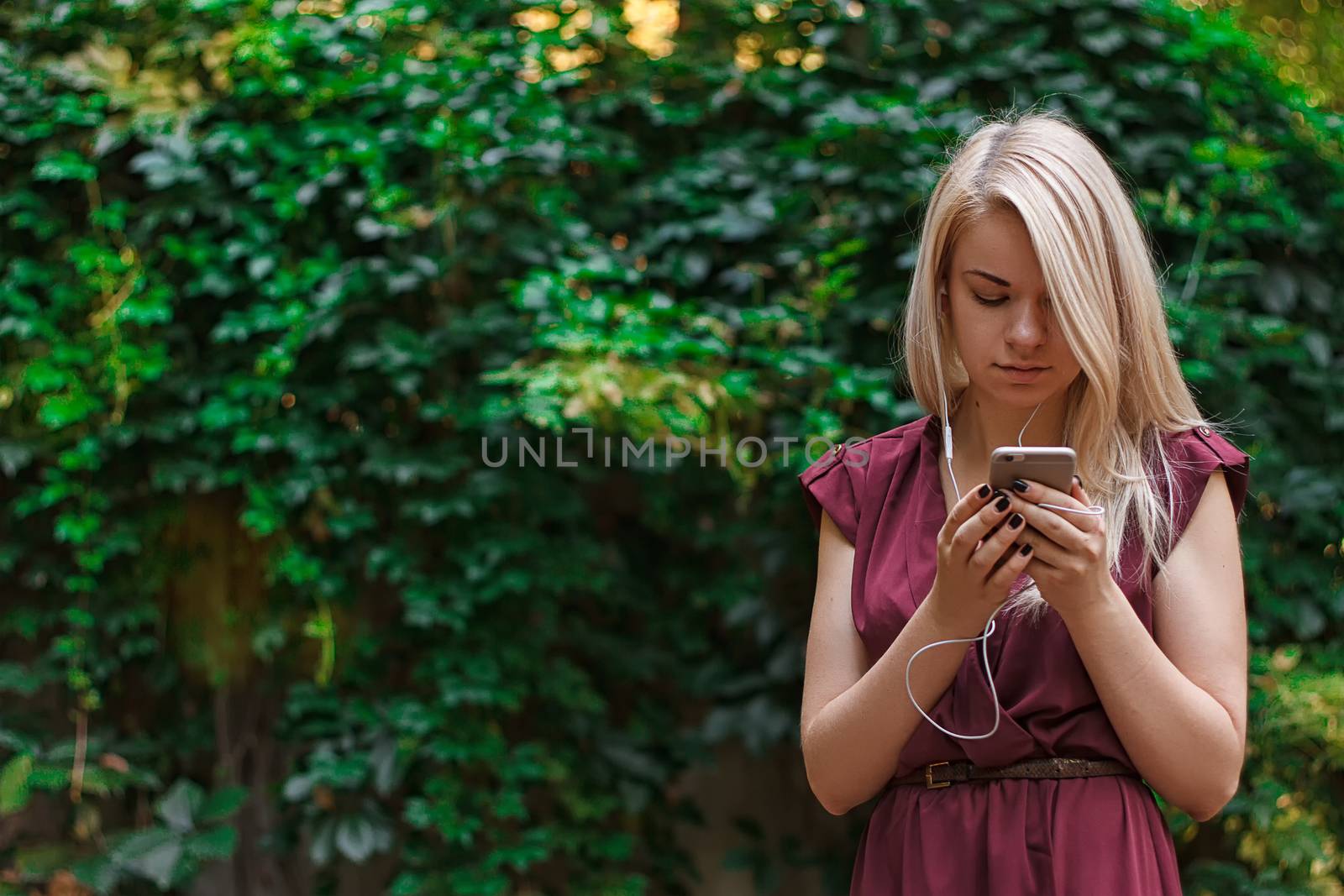 Young attractive woman is texting with her smartphone by victosha