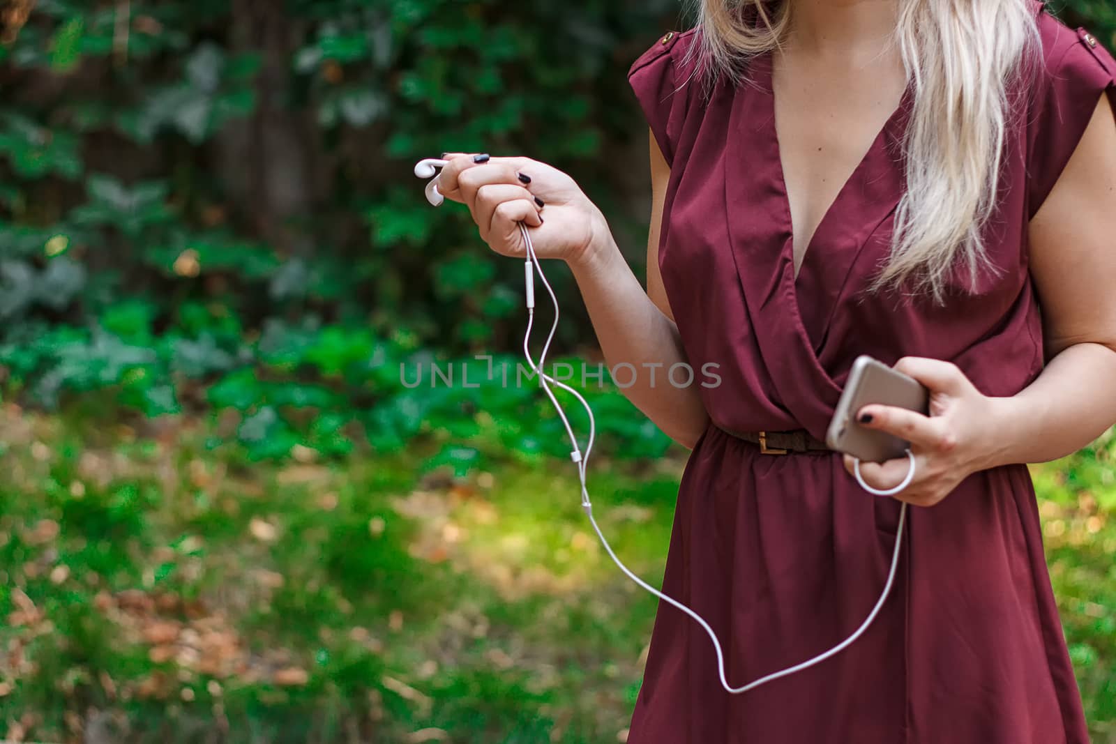 Headphones from a mobile phone in female hands by victosha