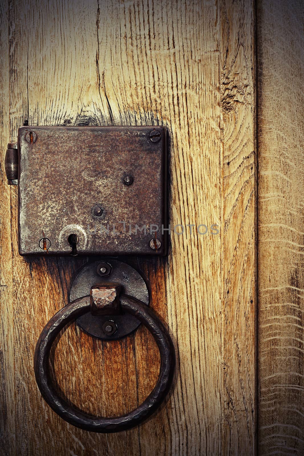 detail of old oak wood gate with rusty metallic hasp