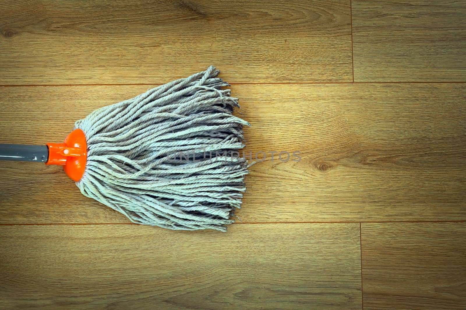 closeup of mop head cleaning on wooden parquet by taviphoto