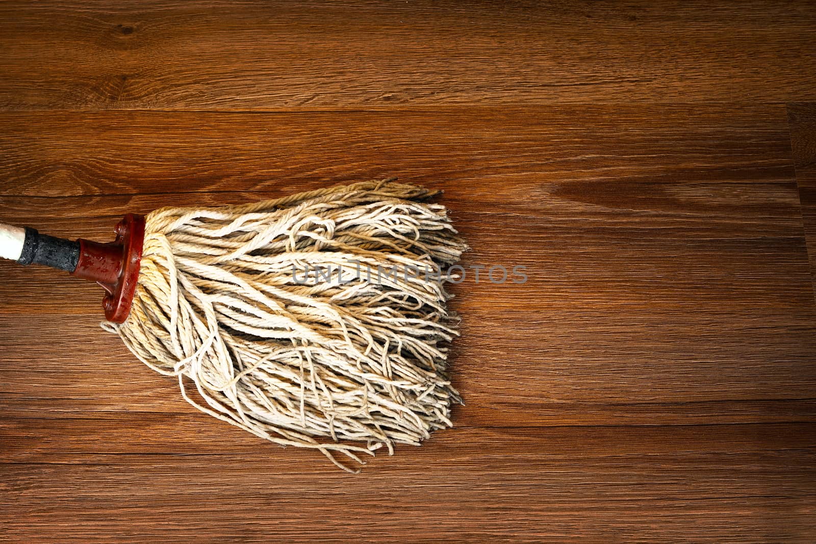 detail of mop cleaning on wood floor, brown parquet