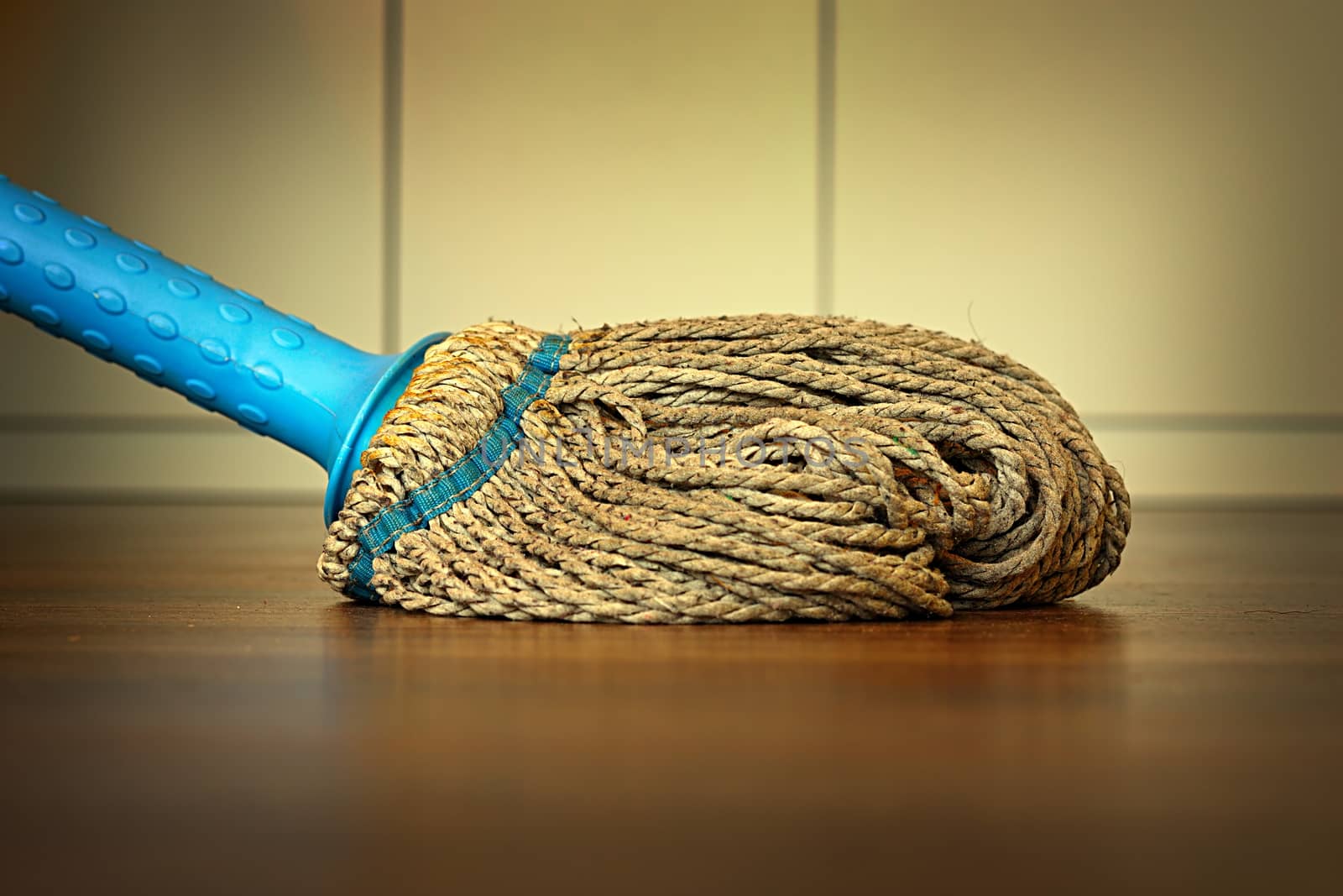 plastic mop on wooden floor by taviphoto