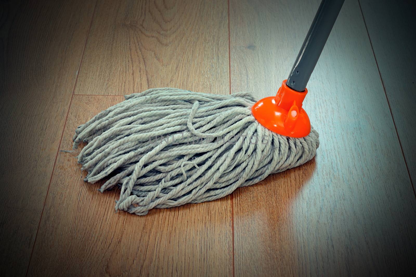 detail of wooden floor cleaning with orange mop