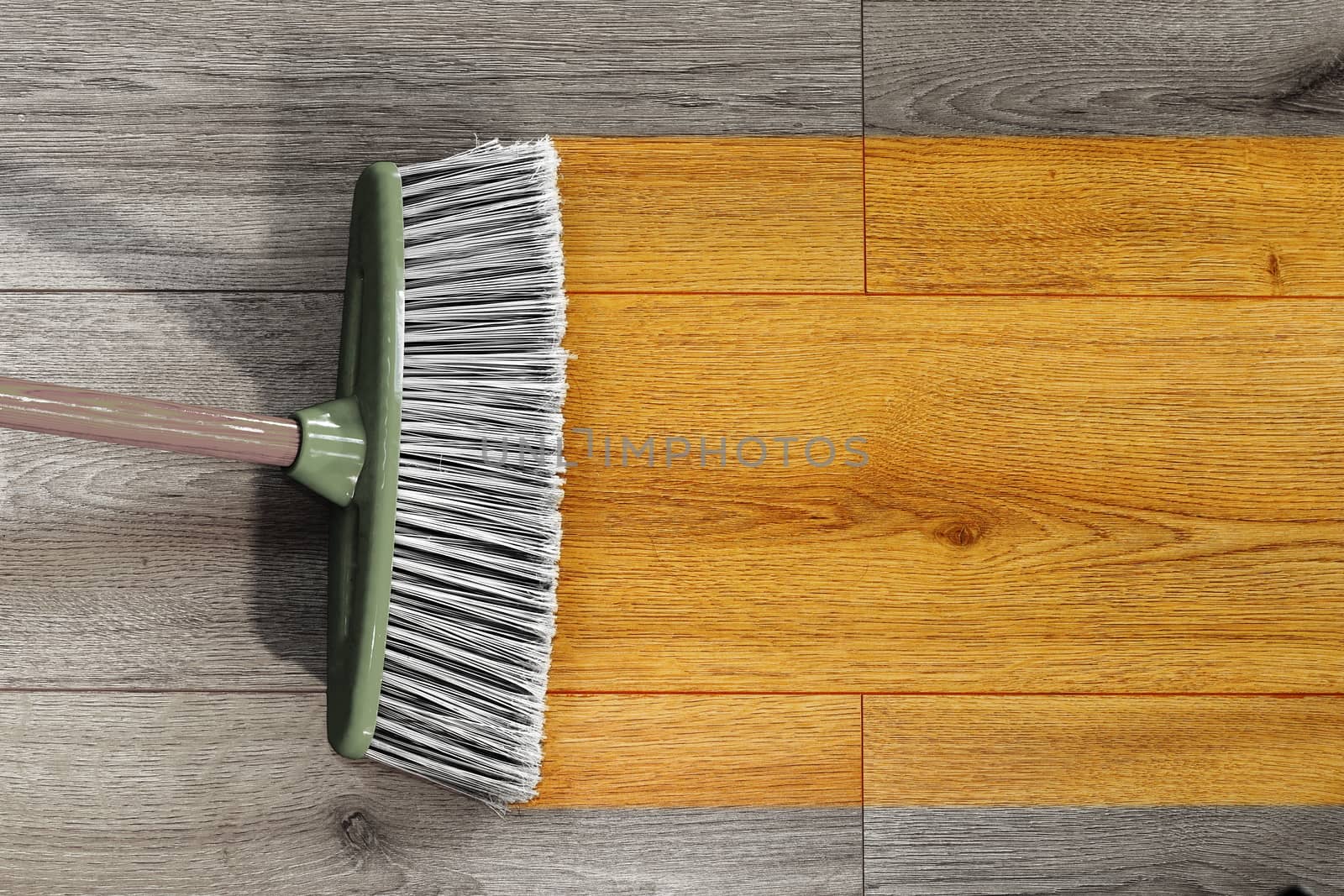 sweeping wooden floor with broom by taviphoto