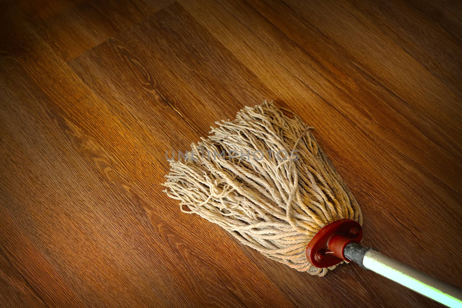 washing the wood floor with an old used mop