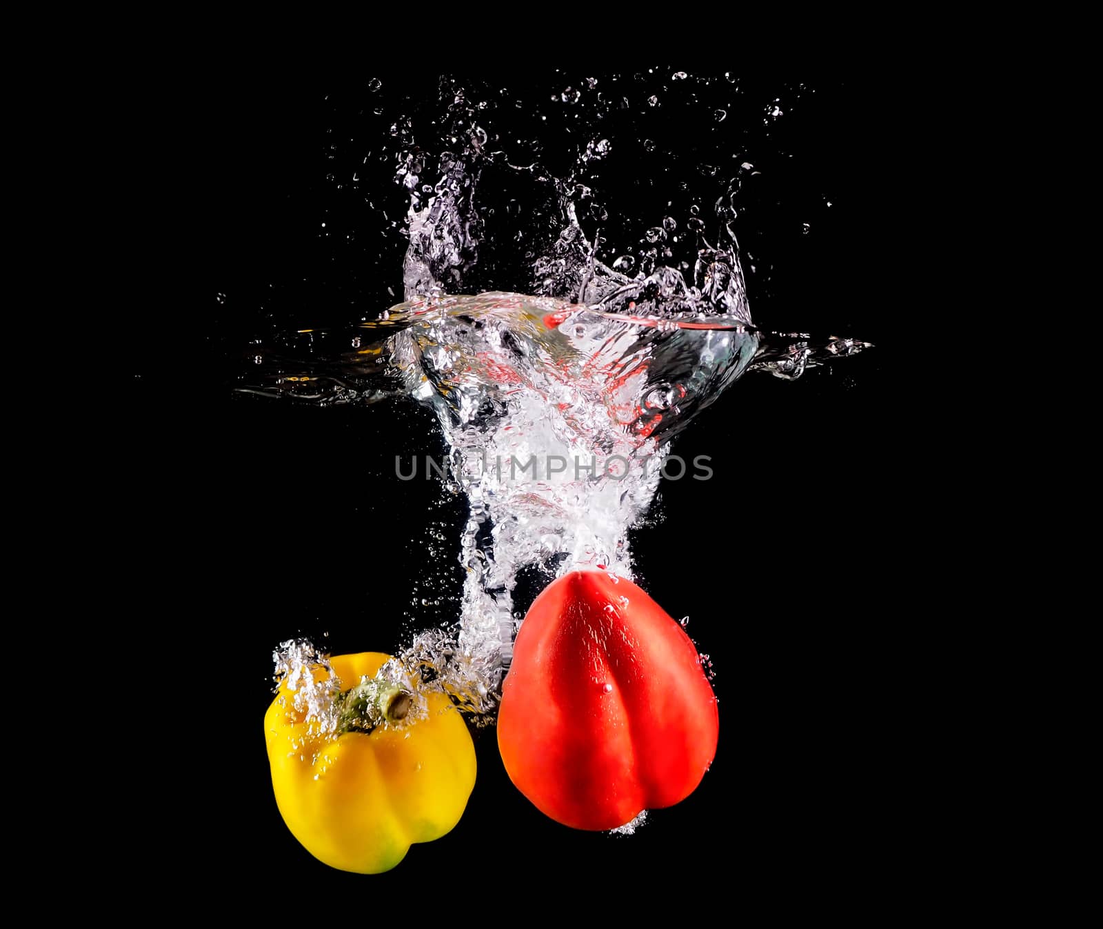 Fresh Bell pepper making splash in water.