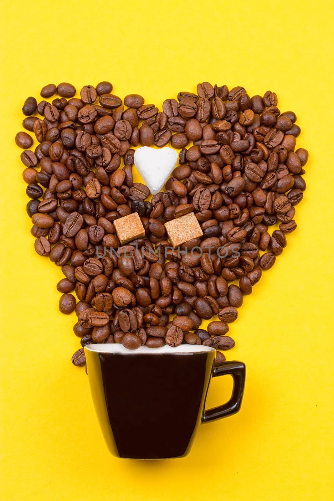 Coffee Cup beans in the form of heart onyellow background. Sugar gingerbread