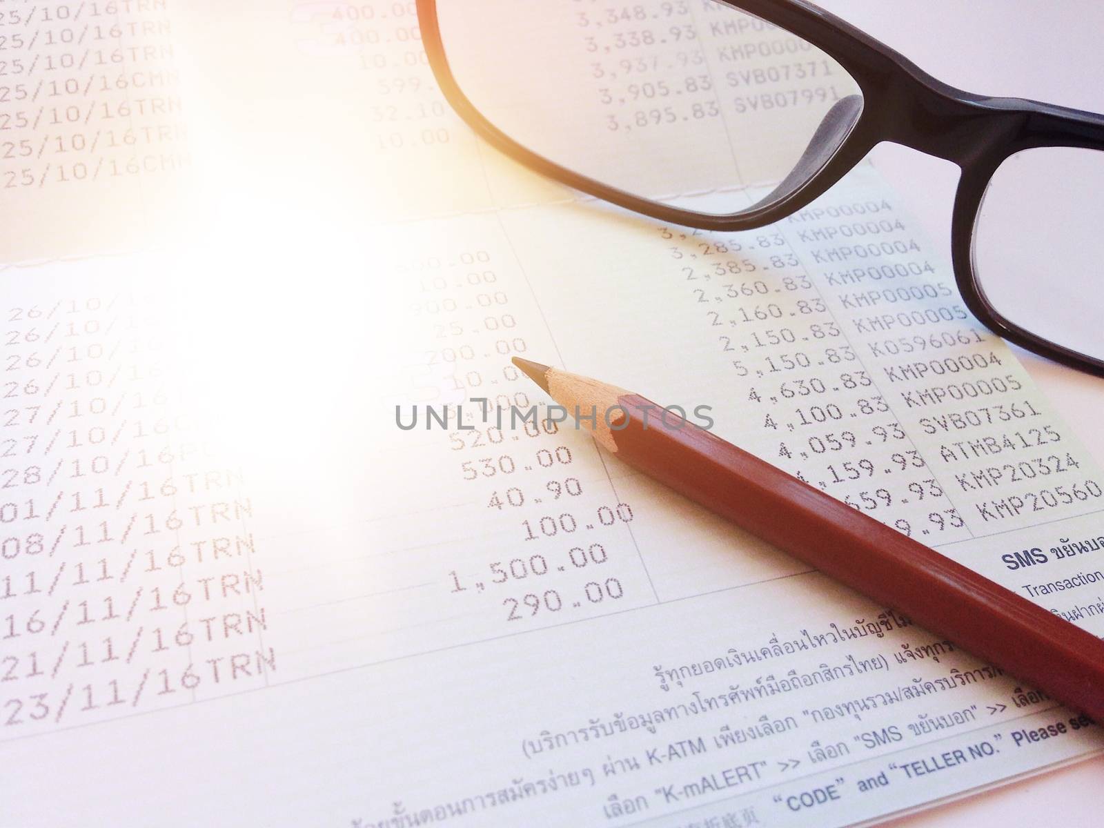 Business, finance, savings or loan background concept ; Pen, eyeglasses and savings account passbook on white background