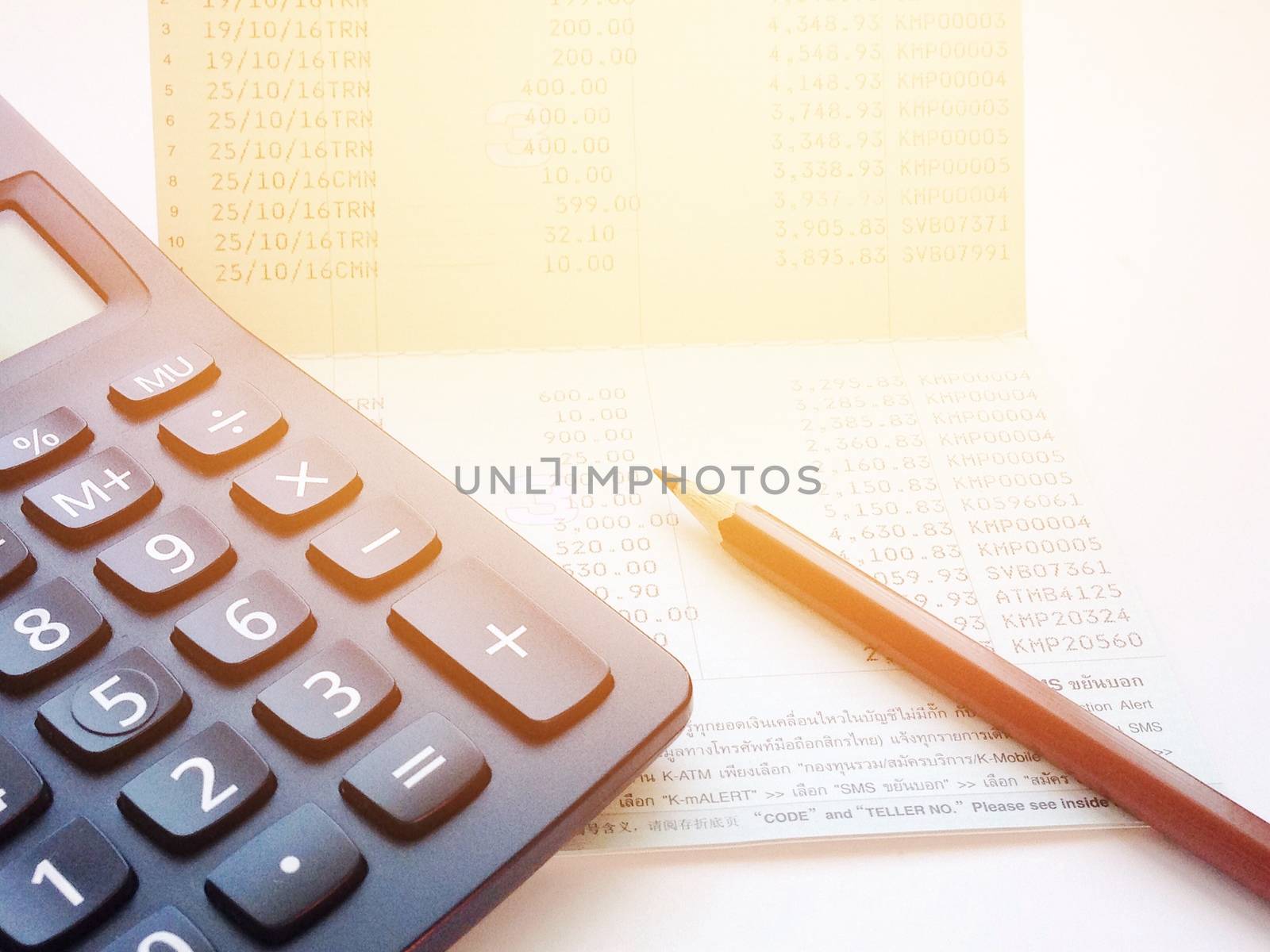 Business, finance, savings or loan concept : Calculator and pencil on saving account passbook or financial statement