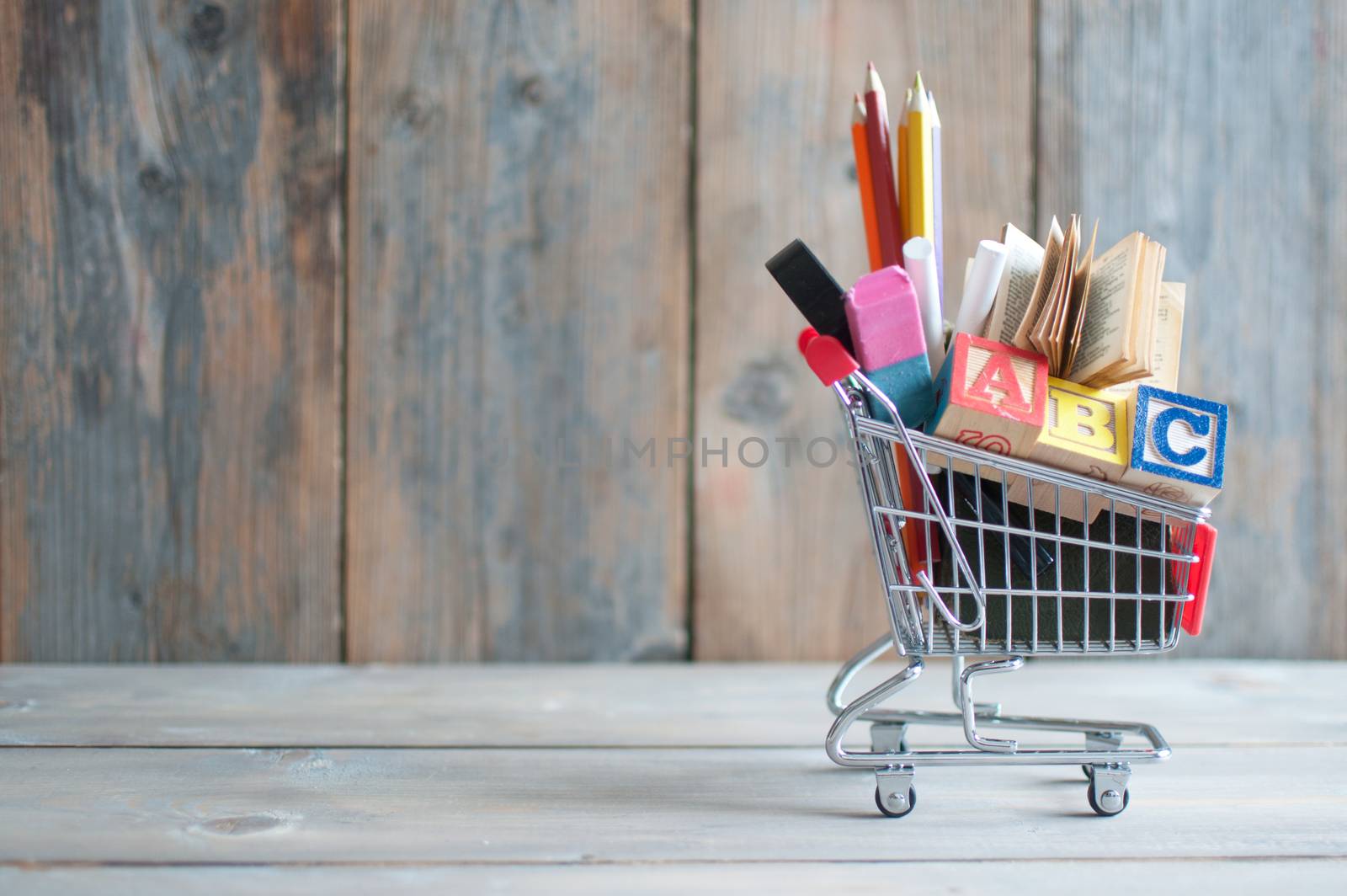 Shopping cart filled with stationery with background space 