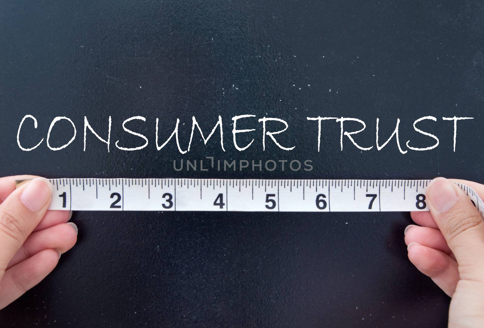 Hands measuring consumer trust on a chalkboard