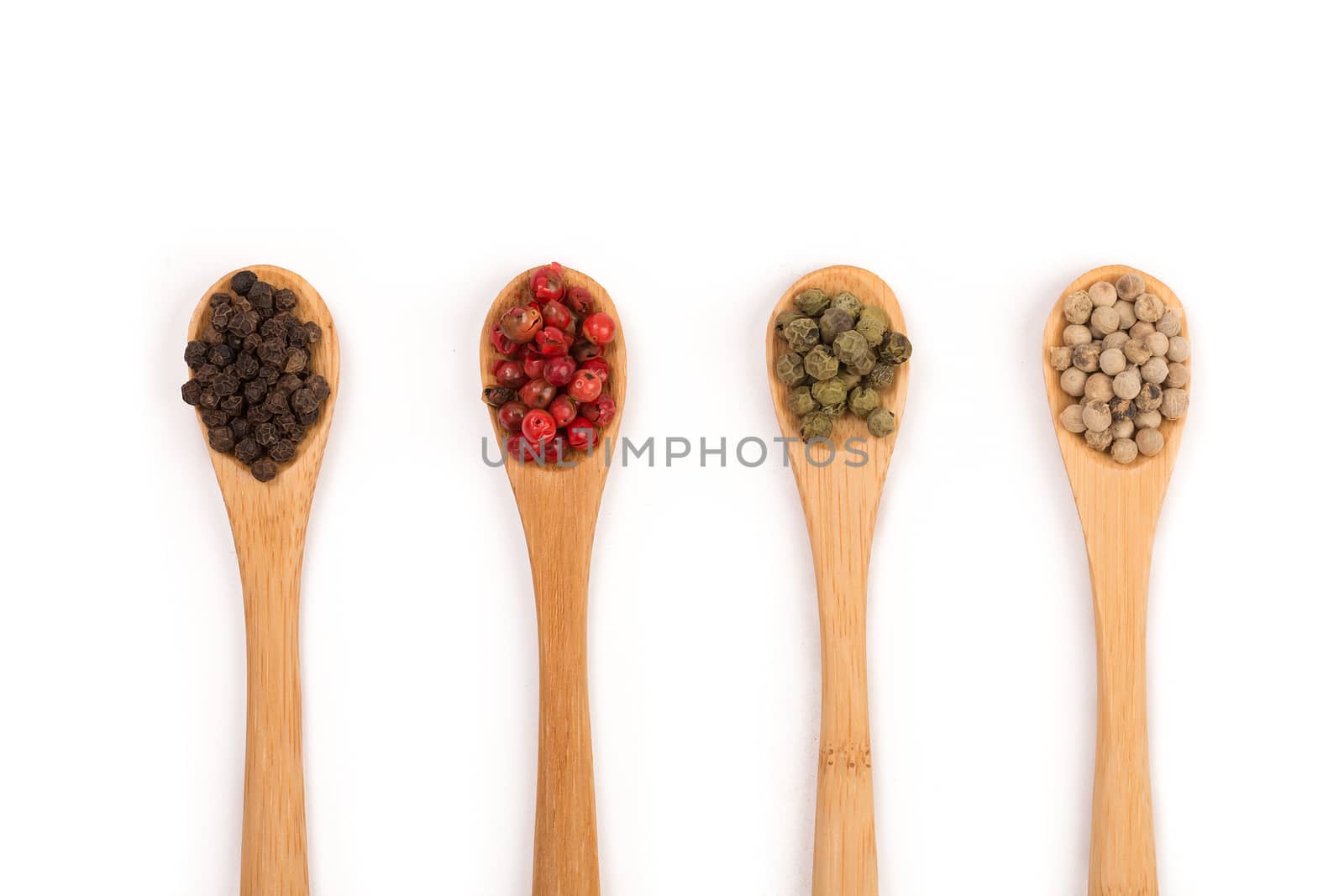 Wooden spoons with various pepper spice on white background.