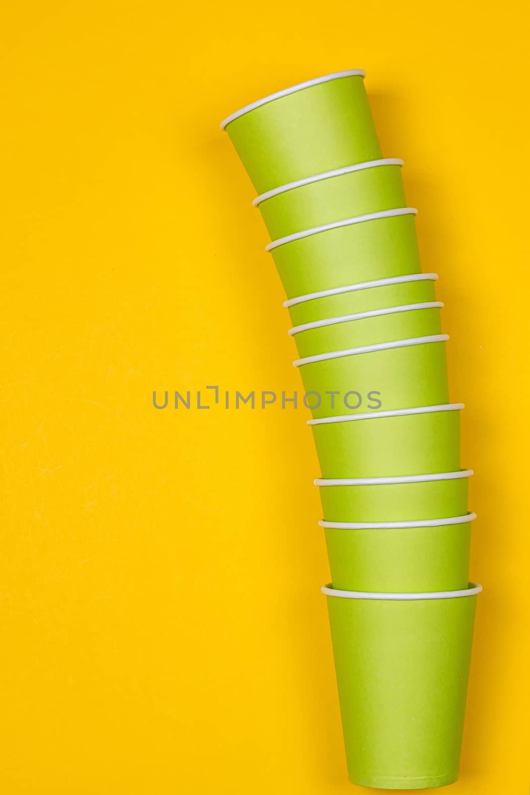 Set of green paper cups on a yellow background