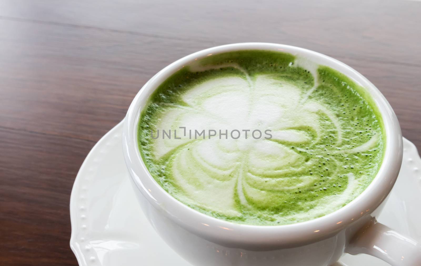 Closeup cup of hot matcha latte art on wood background by pt.pongsak@gmail.com