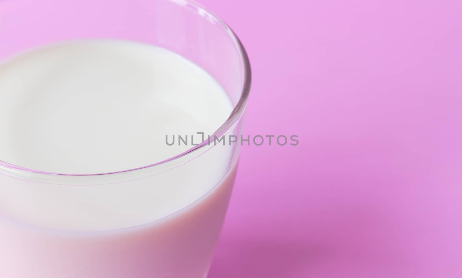 Closeup glass of milk on pink background, food and drink for healthy concept, selective and soft focus