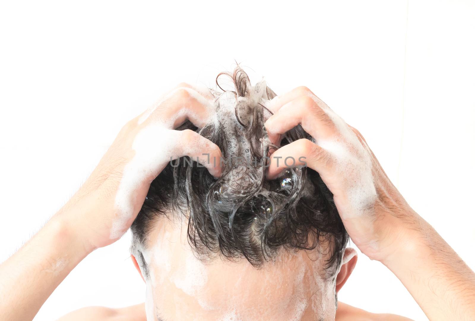 Closeup young man washing hair with white background, health care concept