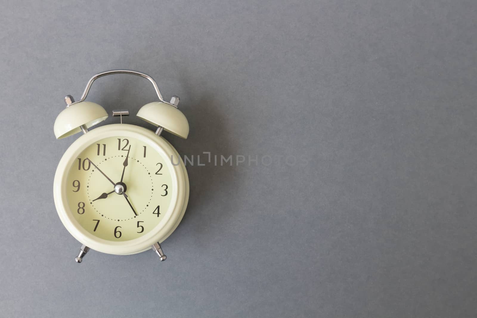 Retro alarm clock on grey background, time concept