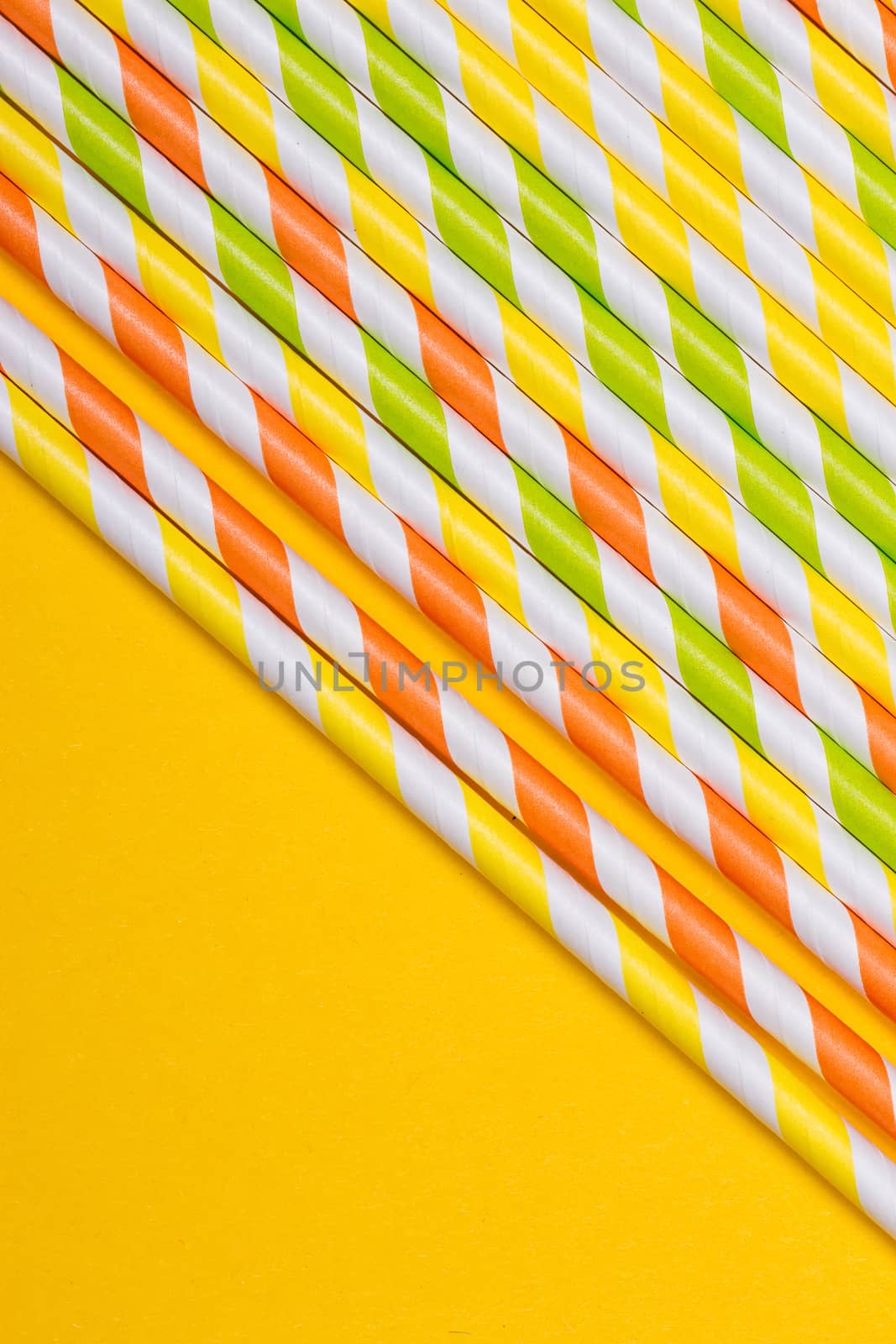 close-up colorful fancy drinking straws, fancy tube for party on the yellow background