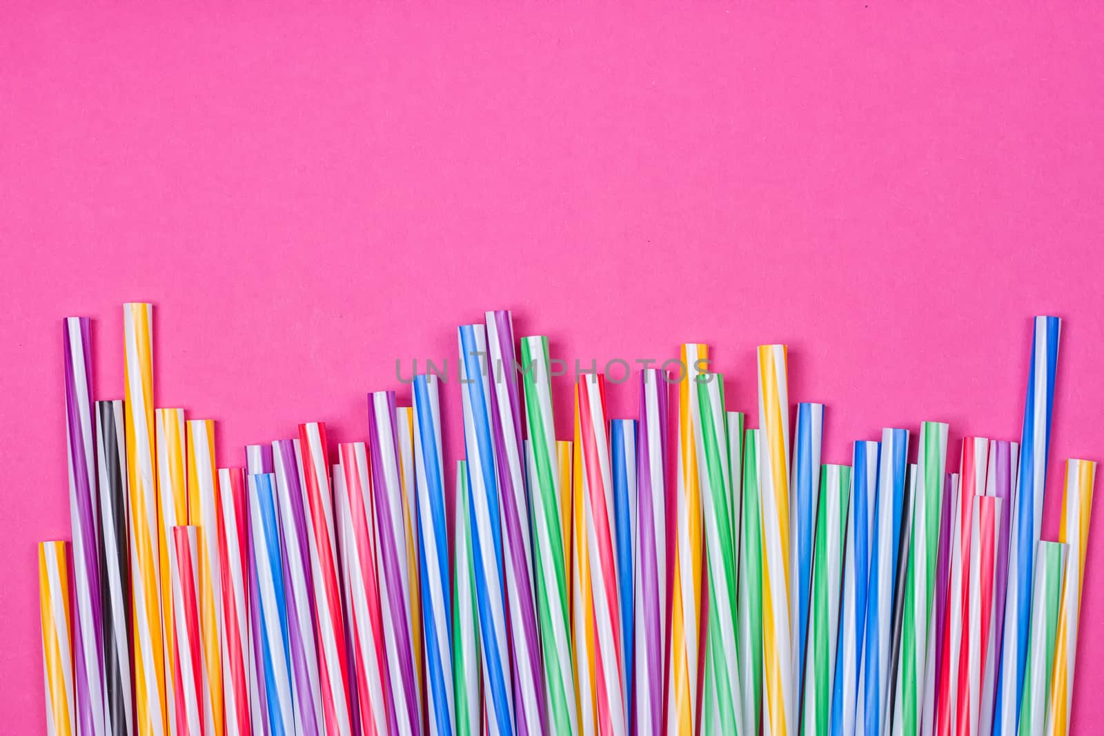 close-up colorful fancy drinking straws, fancy tube for party on the pink background