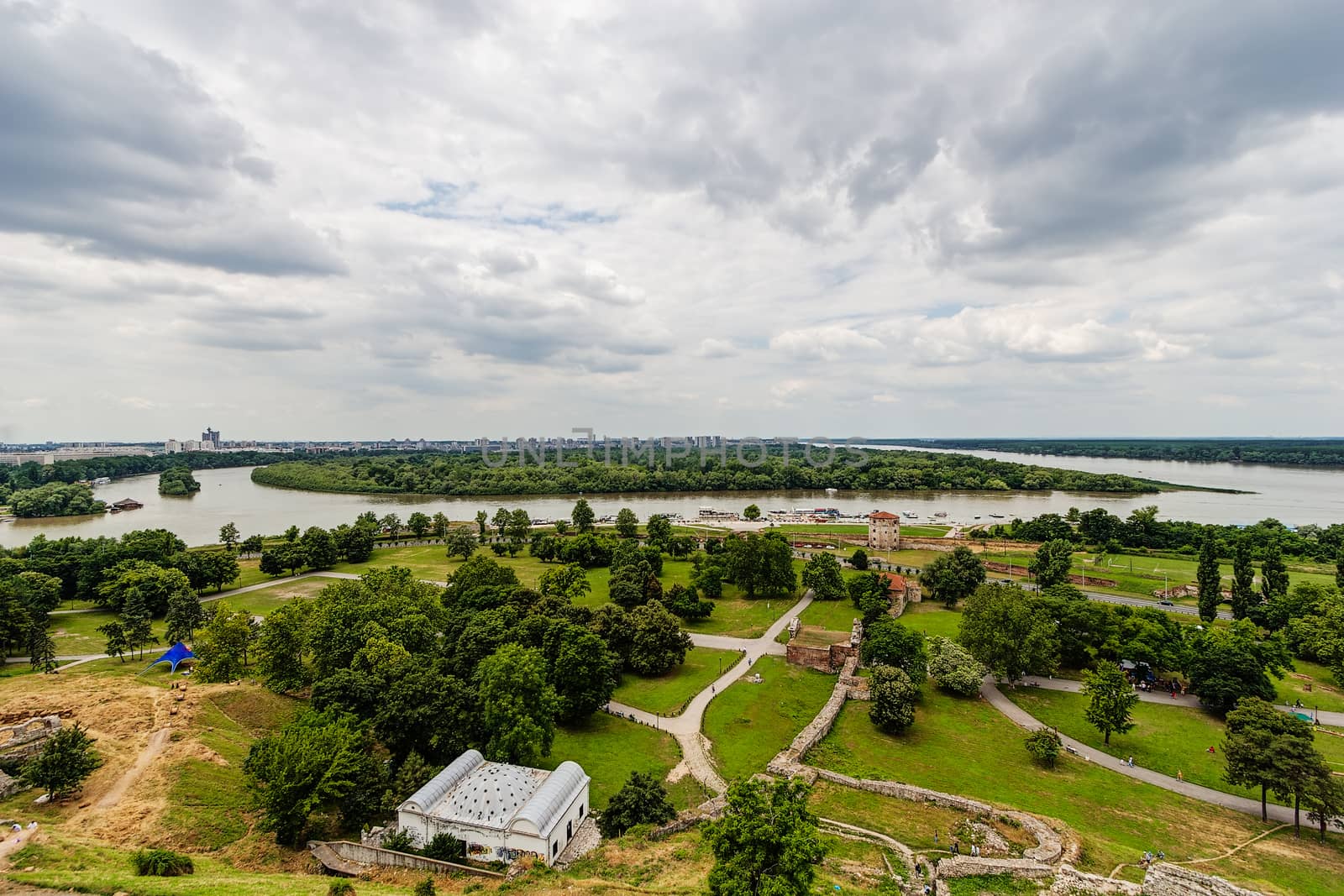 Belgrade fortress and Kalemegdan park with dramatic clouds and green foliage