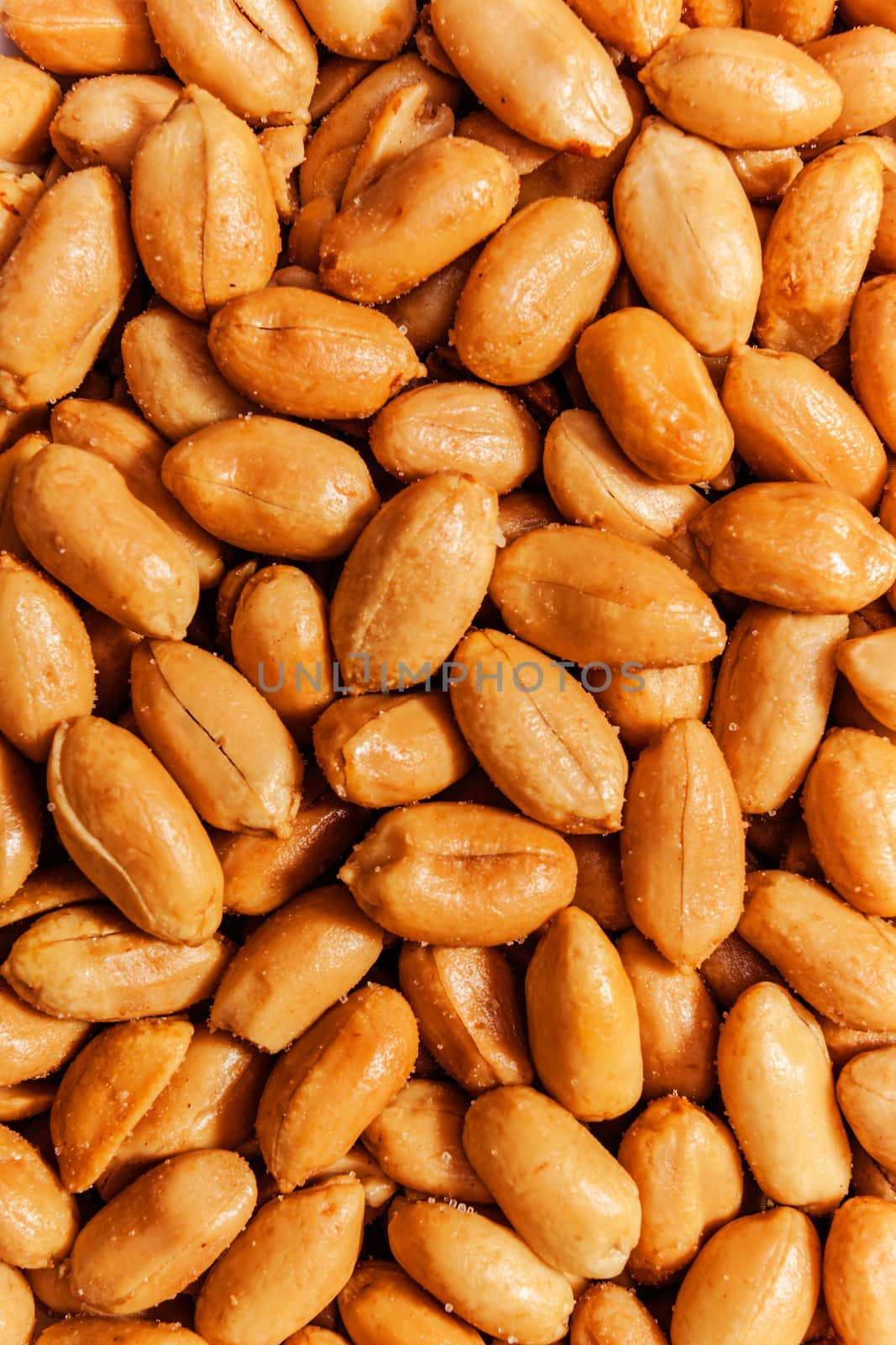 Roasted peanuts in closeup on the white background