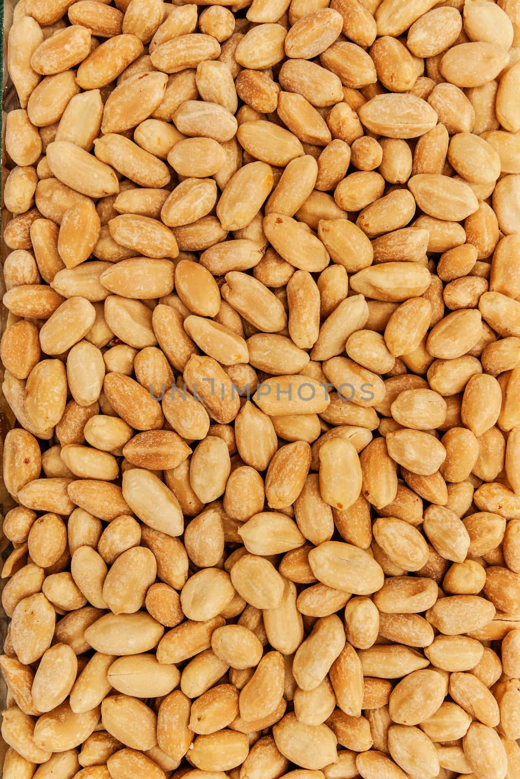 Roasted peanuts in closeup on the white background