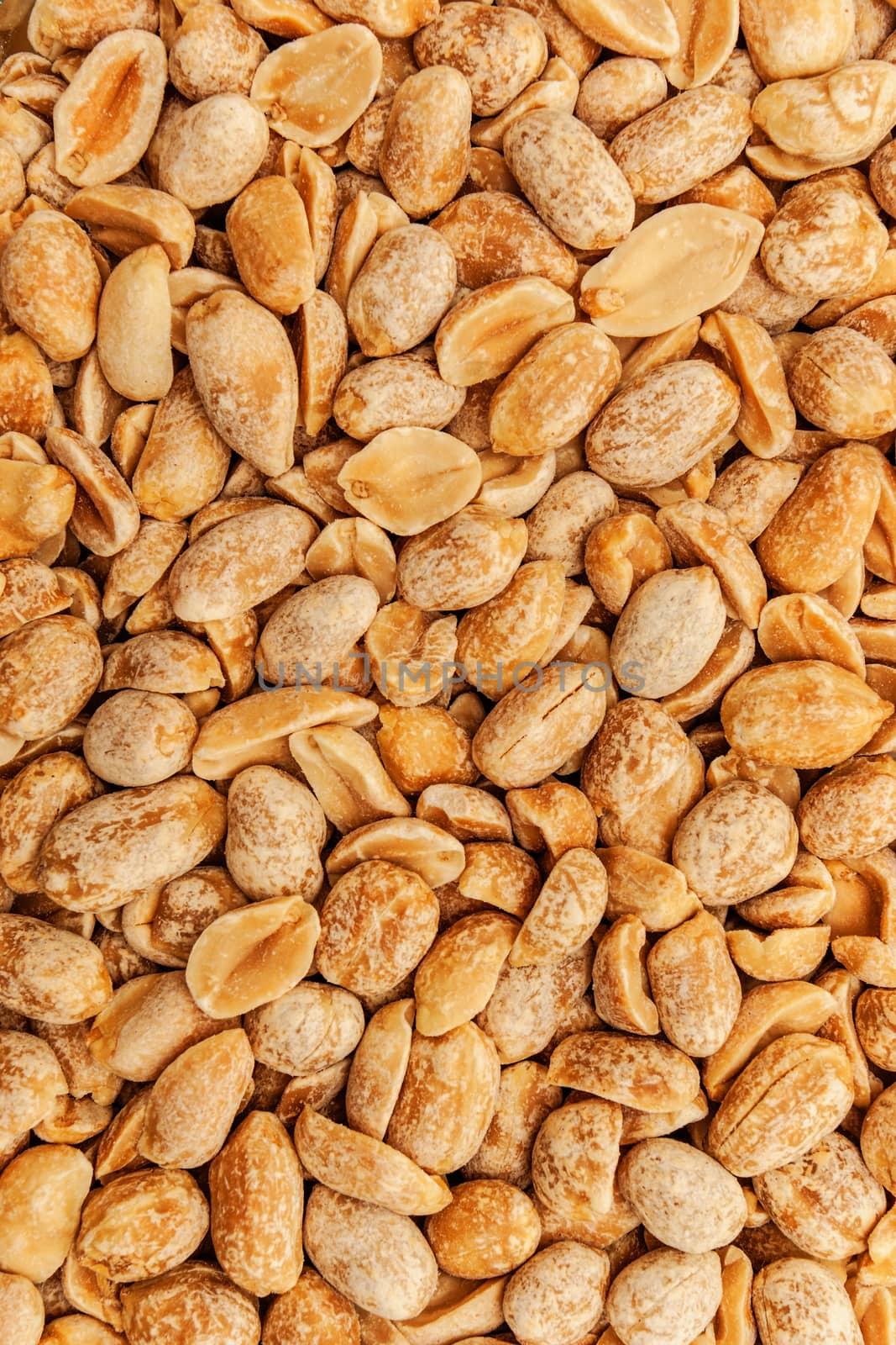 Roasted peanuts in closeup on the white background