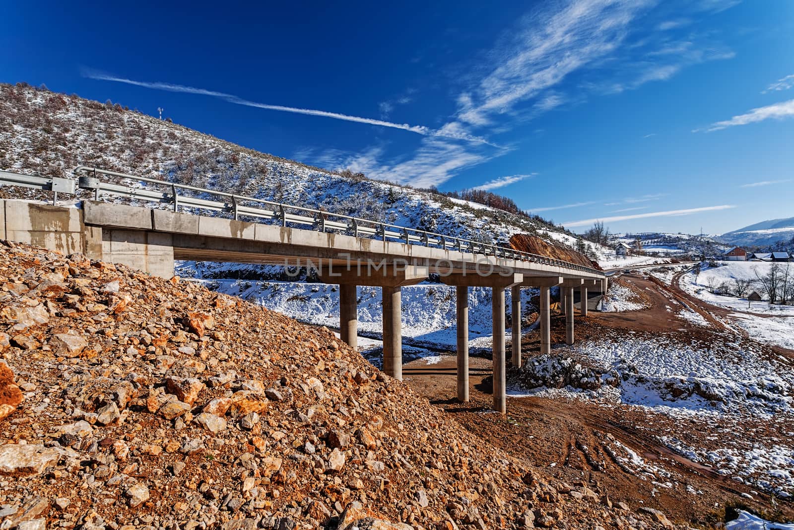 Mountain bridge in winter with snow and blue sky by vladimirnenezic