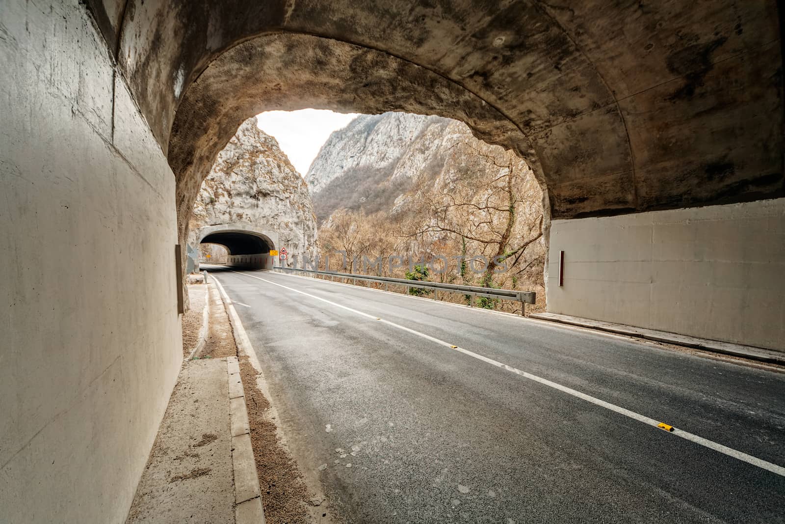 Tunnel on the road in the canyon during the winter on a cloudy day