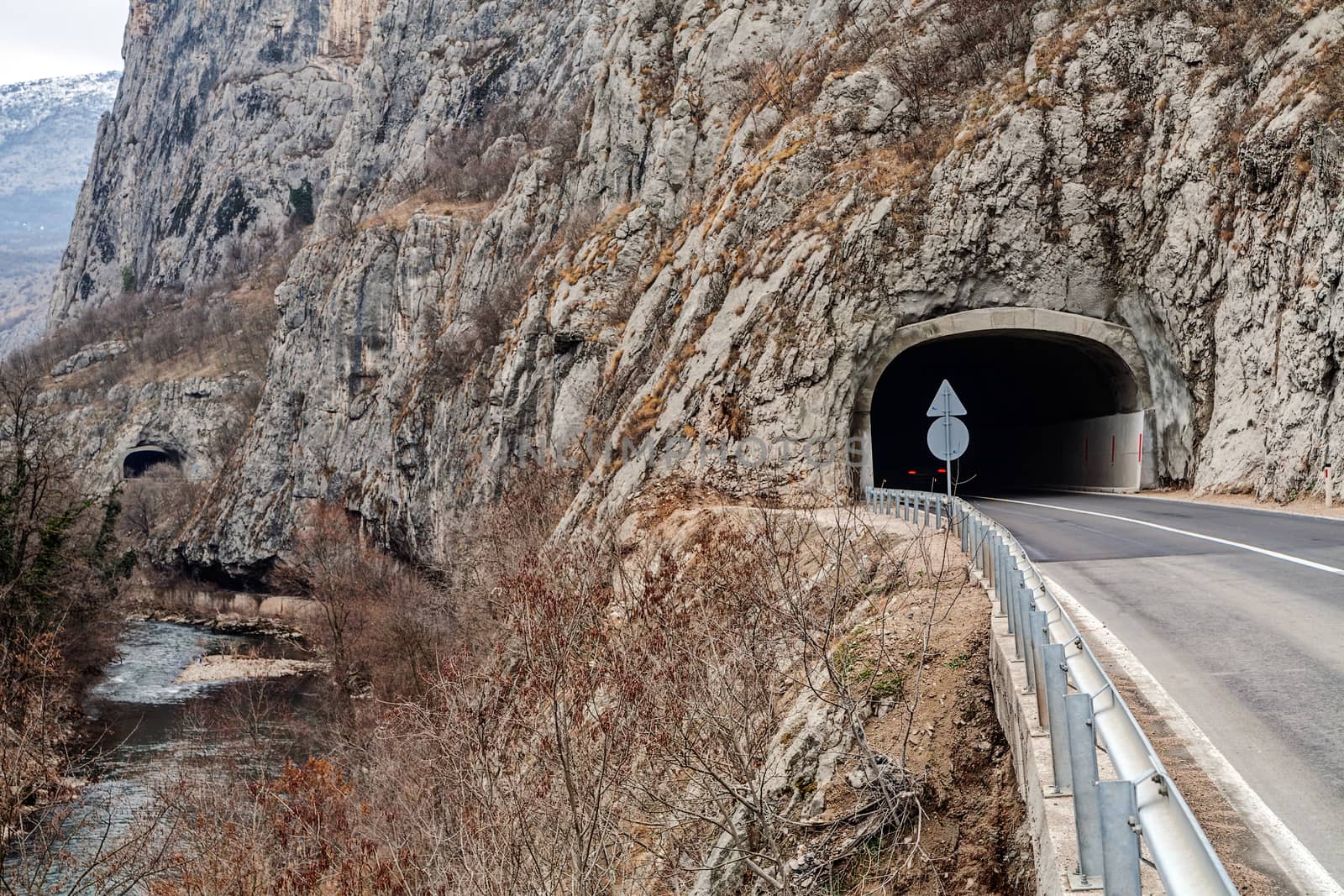 Tunnel on the road in the canyon during the winter on a cloudy day