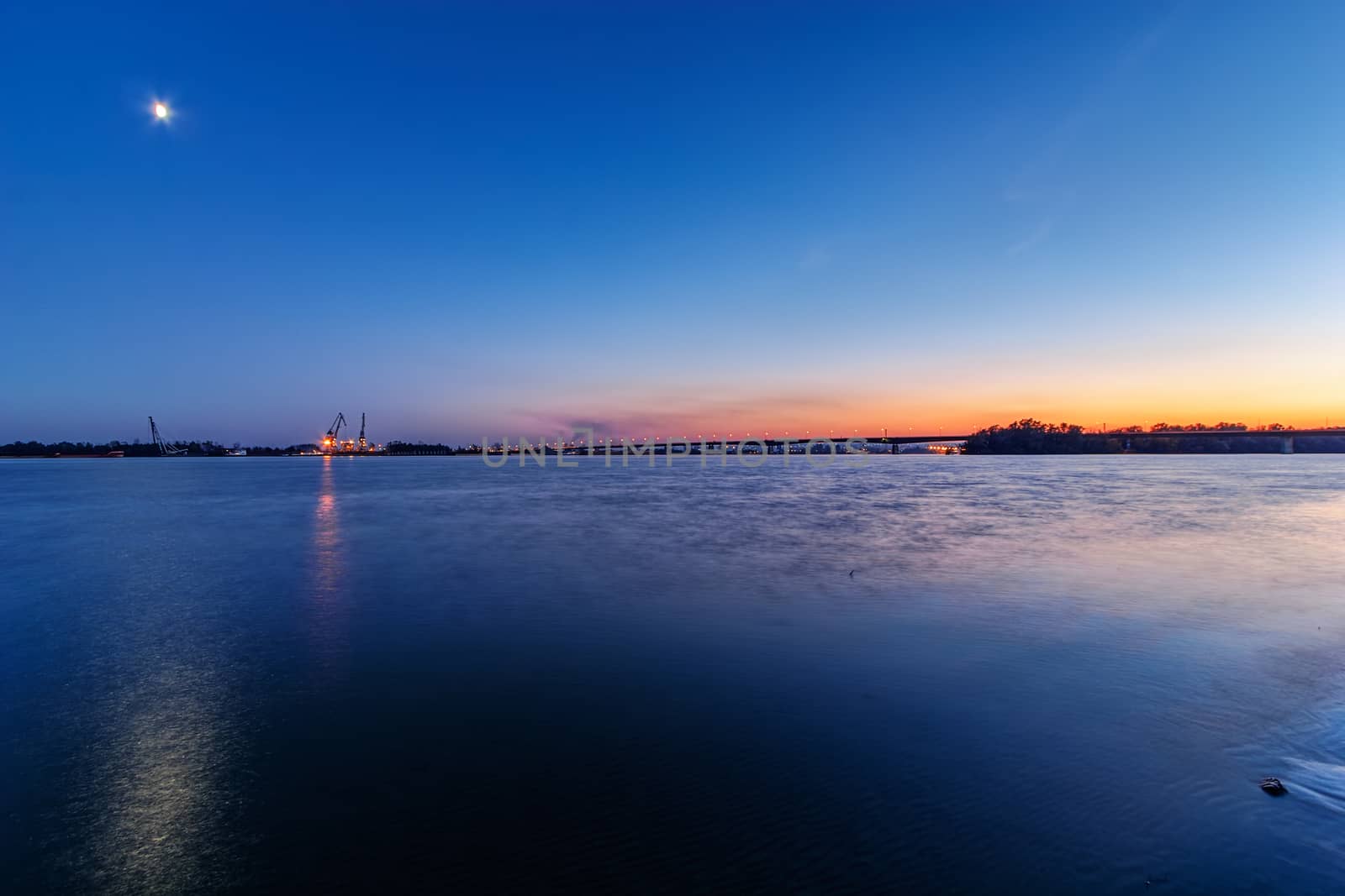 Steel bridge across river at night by vladimirnenezic