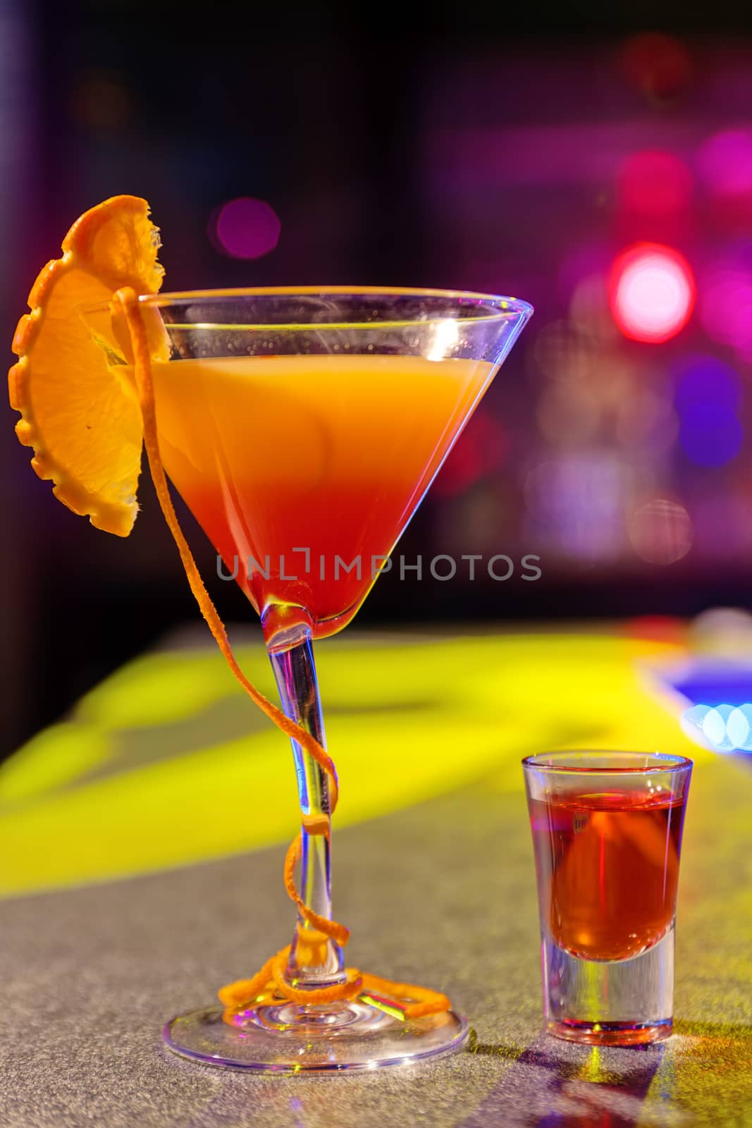 cocktail at bar in a night club with vivid colors by vladimirnenezic