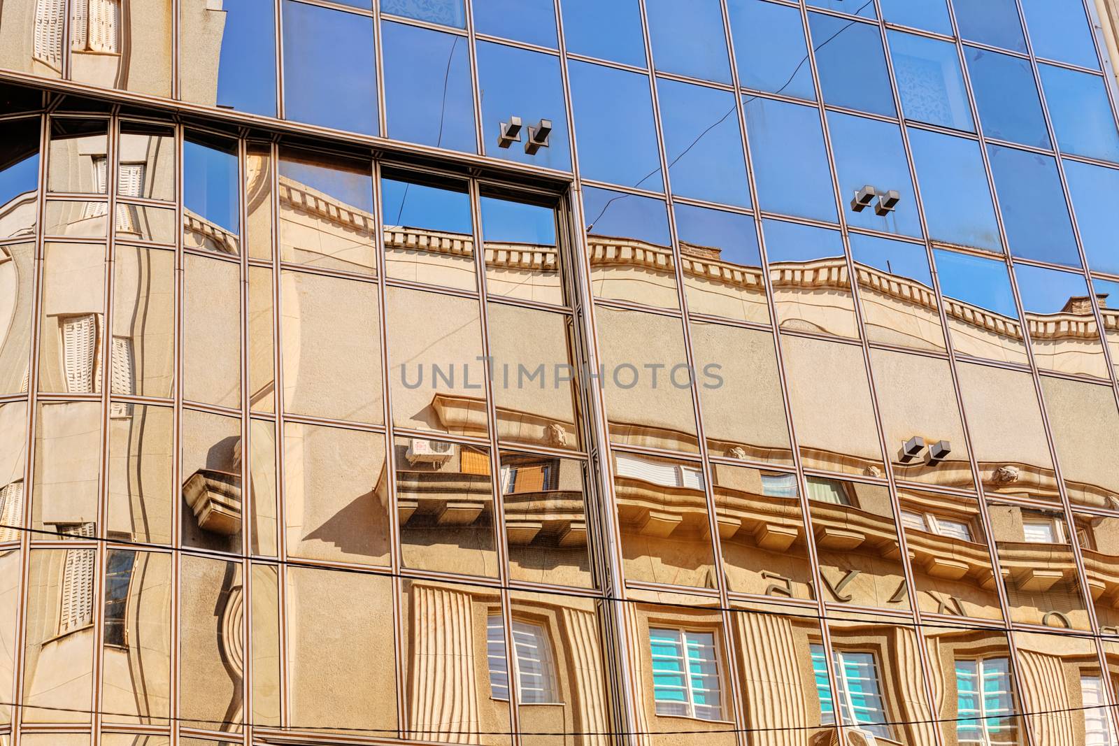 reflection of stone facade on modern glass facade