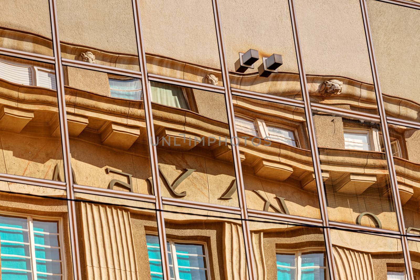 reflection of stone facade on modern glass facade