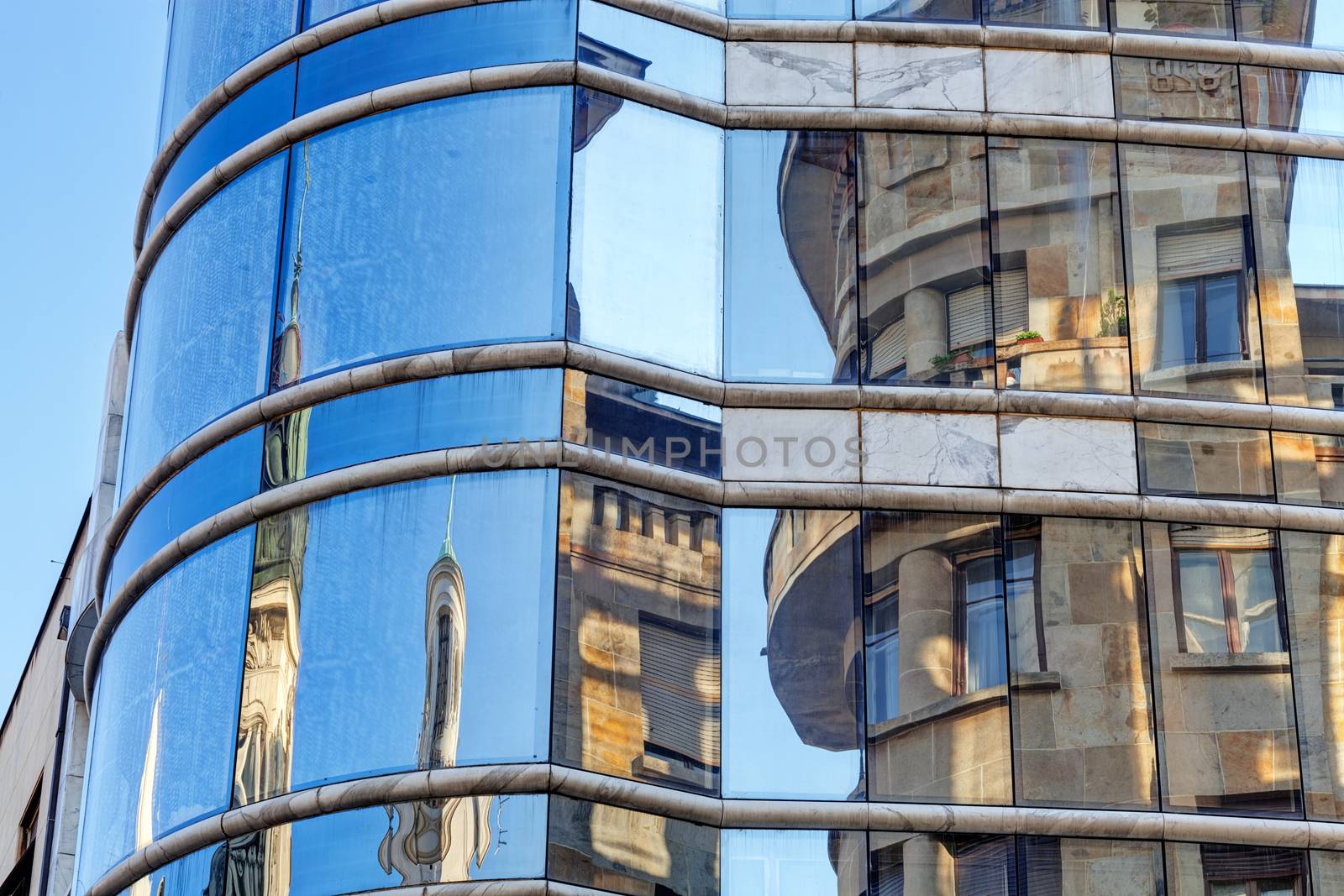 reflection of stone facade on modern glass facade