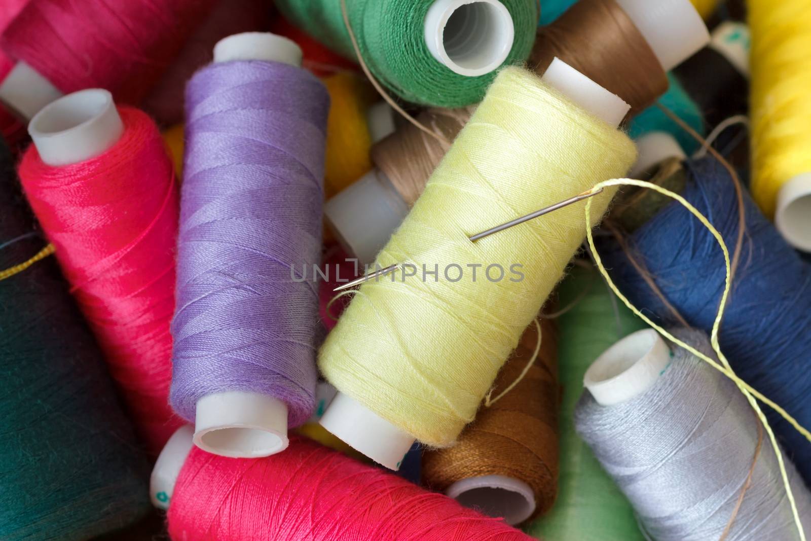 Pile of coloured bobbins of thread by fogen